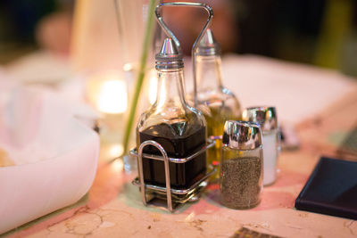 Close-up of balsamic vinegar with olive oil by salt and pepper on table