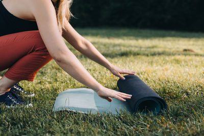 Low section of woman rolling out an exercise mar 