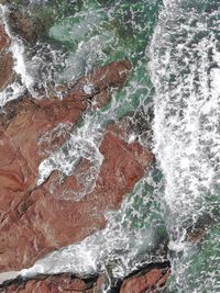 Full frame shot of sea waves splashing on rocks