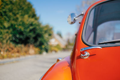 Close-up of orange car on road