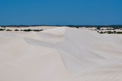 Sand dunes in desert against clear sky