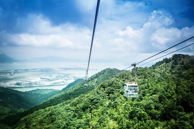 Overhead cable car over mountains against sky