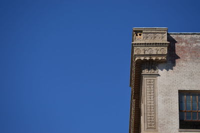 Low angle view of buildings against clear blue sky