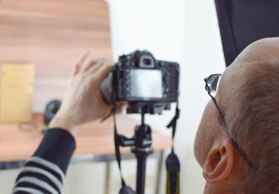 Rear view of man photographing indoors