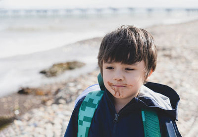 Close-up of boy with messy mouth standing at beach