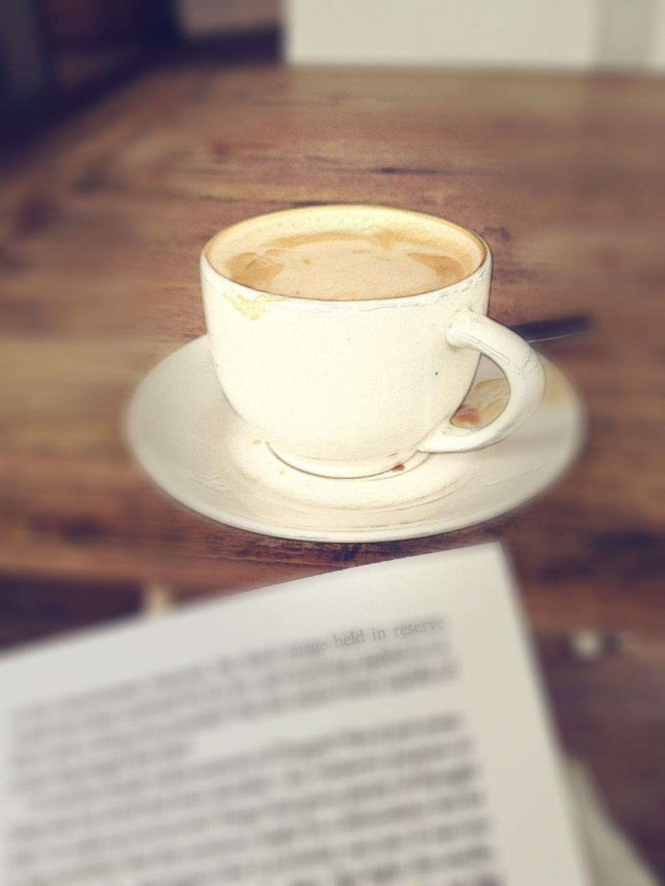 indoors, drink, table, refreshment, coffee cup, food and drink, coffee - drink, still life, close-up, selective focus, freshness, saucer, coffee, focus on foreground, book, text, cup, communication, western script, no people