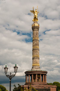 Low angle view of eiffel tower against cloudy sky