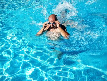 High angle view of man wearing goggles in swimming pool