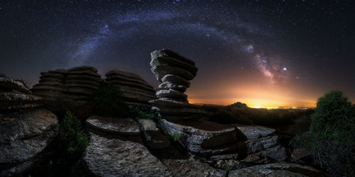 Low angle view of rocks against sky at night