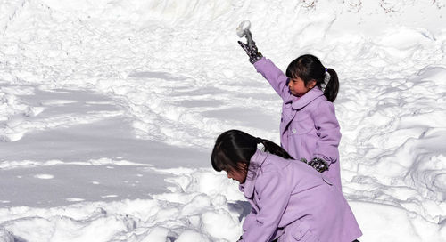 Rear view of girl on snow field during winter