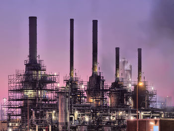 Low angle view of chemical plant against purple sky
