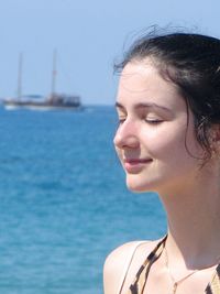 Close-up of young woman in sea against sky