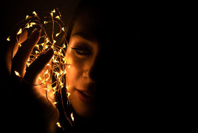 Close-up portrait of woman against black background