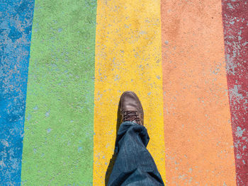Low section of man walking on multi colored footpath