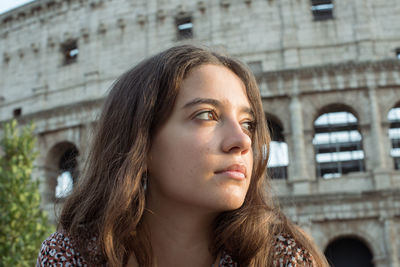 Portrait of young woman standing in city