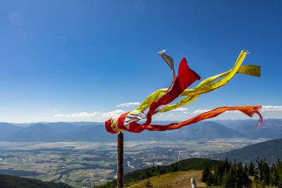 Red flag on mountain against blue sky