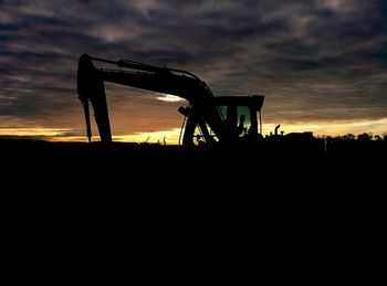 Silhouette of landscape against cloudy sky at sunset