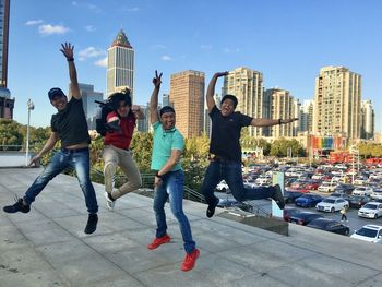 Full length of people with cityscape against sky