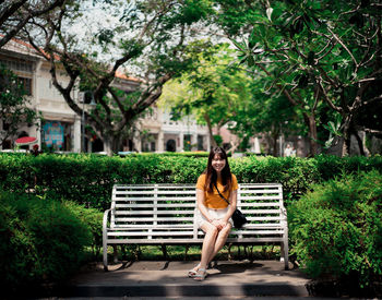 Woman sitting on bench in park