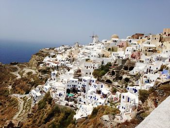 High angle view of townscape by sea against clear sky
