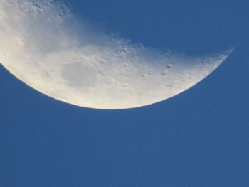 Low angle view of moon against blue sky