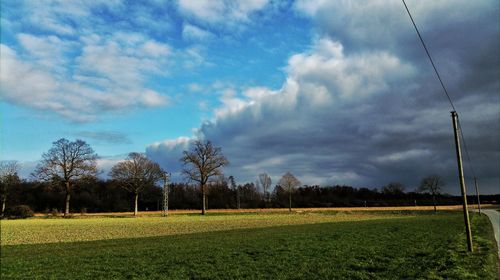 Scenic view of grassy field against cloudy sky