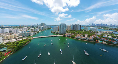 Yachts sailing on river amidst buildings in city