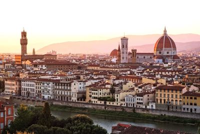 Florence cathedral by buildings against sky during sunset