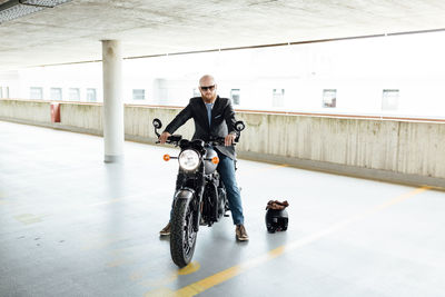 Man sitting on motorcycle in building