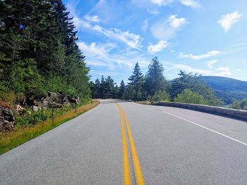 Road amidst trees against sky