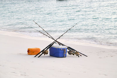 Close-up of fishing gear on beach against sky