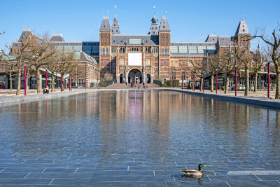 Group of people on water by buildings in city