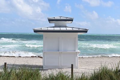 Hut at beach against sky