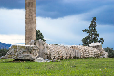 Low angle view of old ruins on field against sky