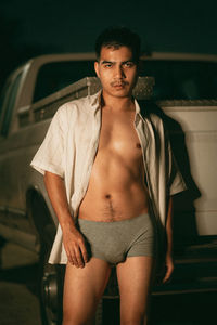 Portrait of young woman standing in car