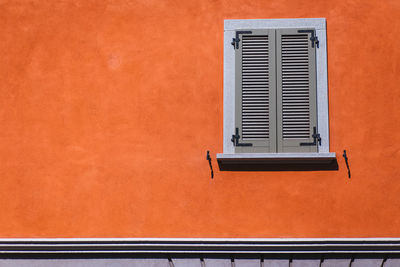 Close-up of window on orange wall