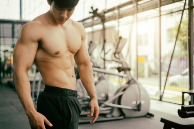 Shirtless young man standing in gym