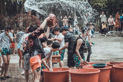 Group of people enjoying in wet city