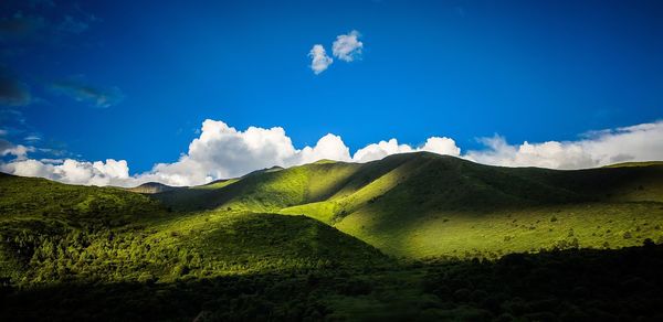 Scenic view of mountains against blue sky