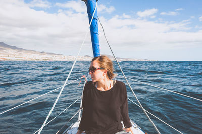 Young woman sitting in boat on sea