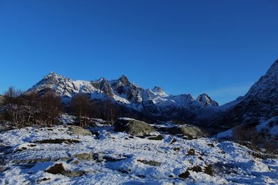 Scenic view of snowcapped mountains against clear blue sky