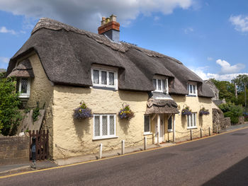 Houses by road against sky in city