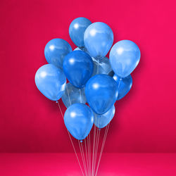 Close-up of heart shaped balloons against red background