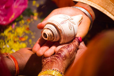 High angle view of couple holding seashell during wedding ceremony