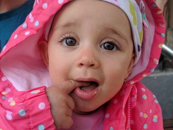 Close-up portrait of cute baby girl wearing pink hooded shirt