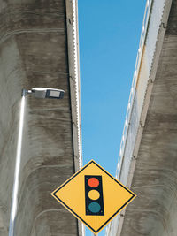 Low angle view of road sign under concrete bridges