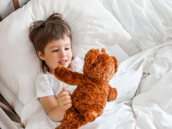 High angle view of cute baby boy on bed