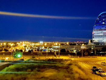 Illuminated city buildings against sky at night