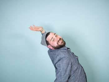 Man standing with umbrella against blue background