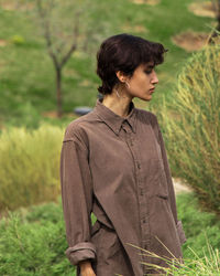 Side view of young woman standing on field